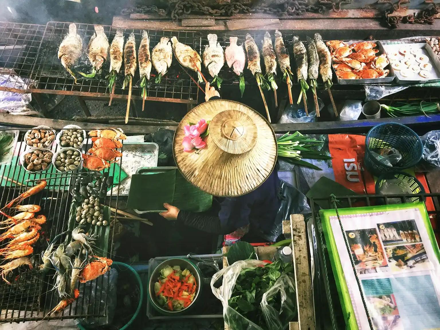 Street food in Thailandia con pesce alla griglia, immagine di copertina per una guida sui vaccini consigliati e sulla salute in viaggio.