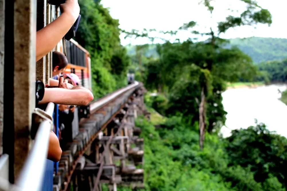 turistas apoiados na janela do comboio a tirar fotos