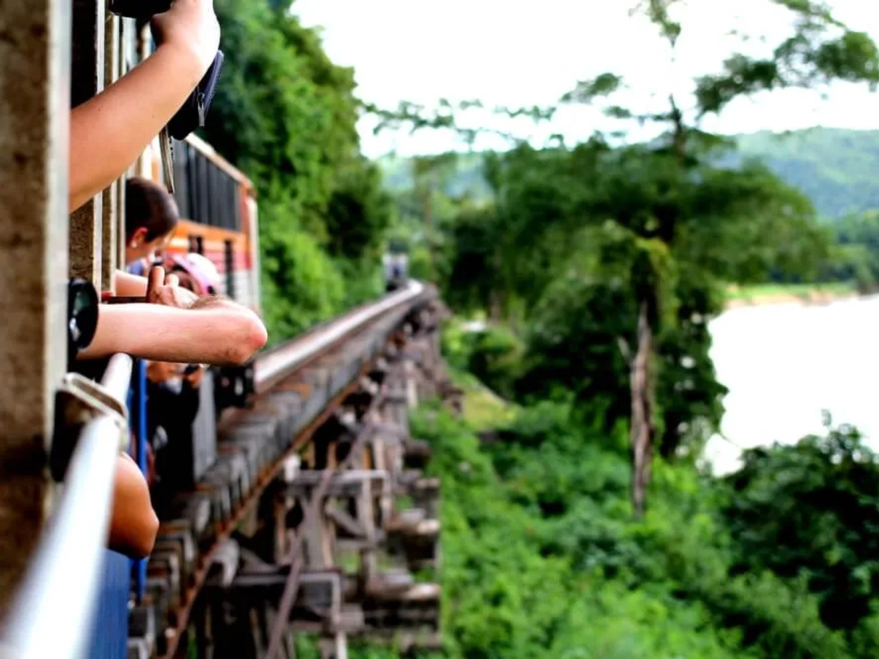 turistas apoiados na janela do comboio a tirar fotos