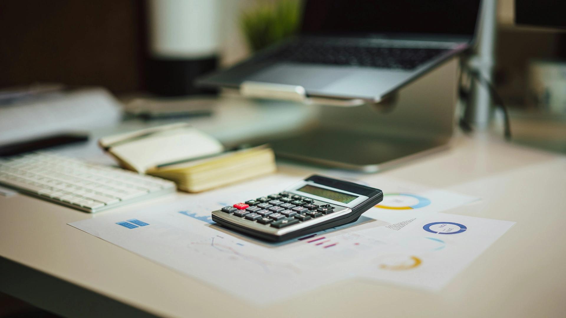 Calculadora y gráficos sobre una mesa para calcular el precio de un seguro de vida para la hipoteca