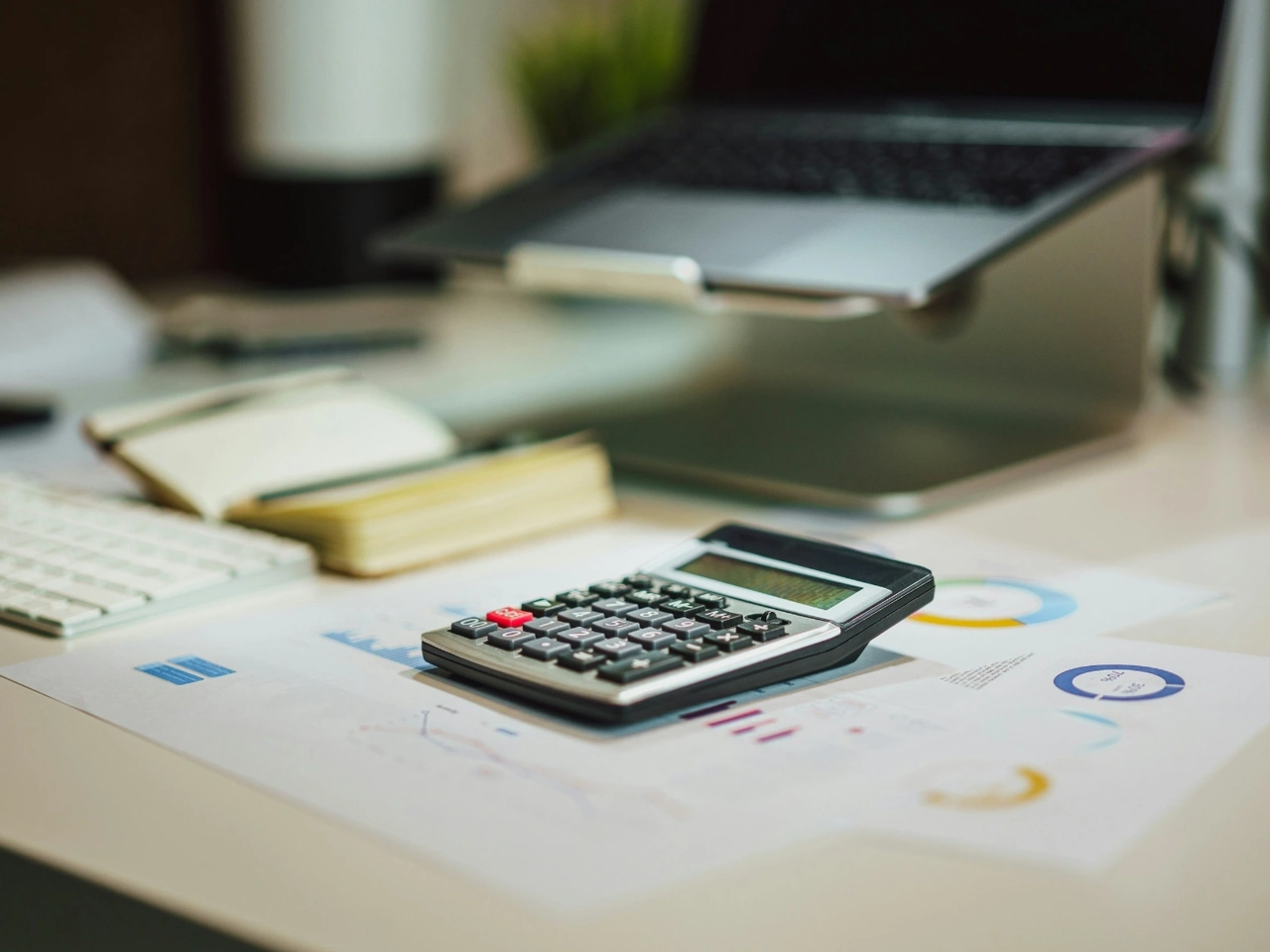 Calculadora y gráficos sobre una mesa para calcular el precio de un seguro de vida para la hipoteca