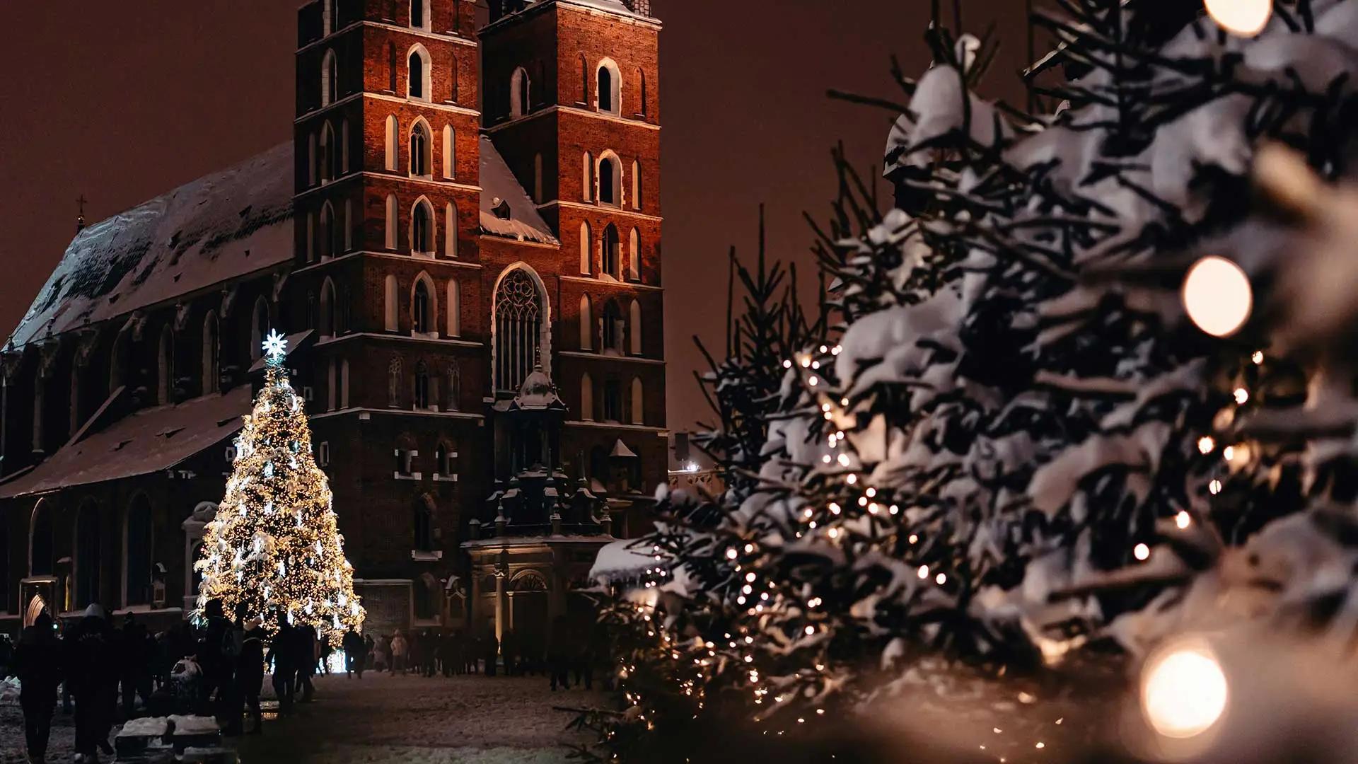 un arbol de navidad junto a una iglesia en polonia