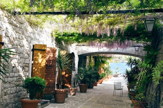 rua em Budva em Montenegro com plantas e uma cadeira ao pé dos vasos