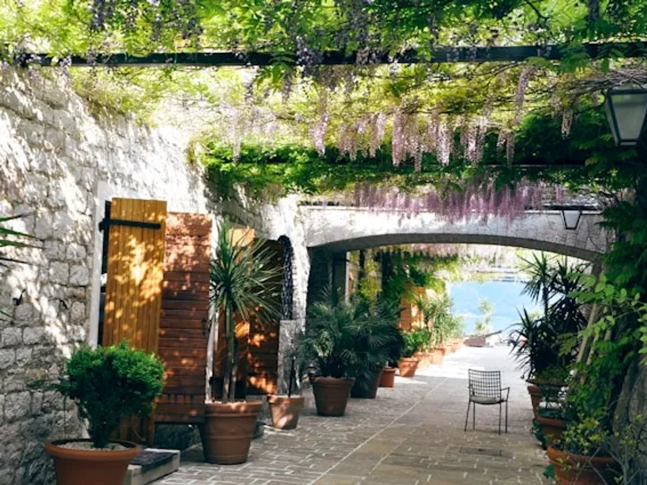 rua em Budva em Montenegro com plantas e uma cadeira ao pé dos vasos