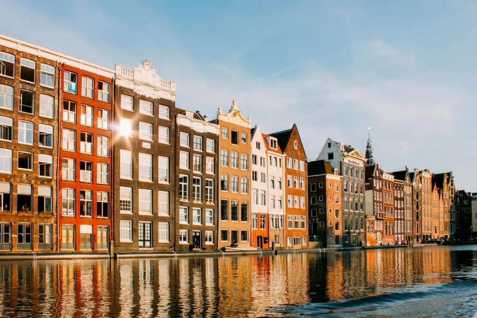 Canales y edificios históricos en Ámsterdam, Países Bajos, reflejados en el agua.