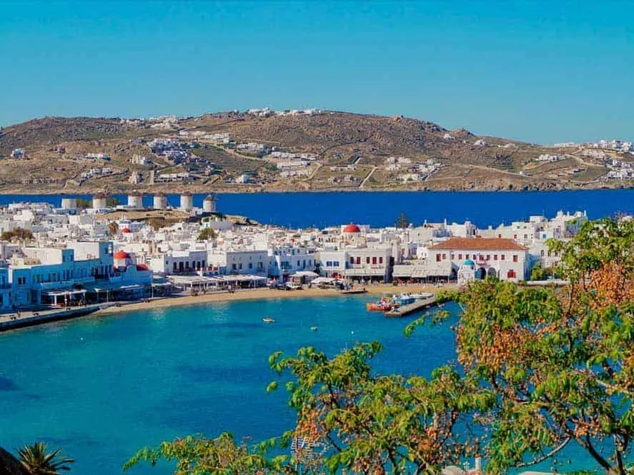 Vista da costa de Mykonos, com casas brancas e águas azuis.