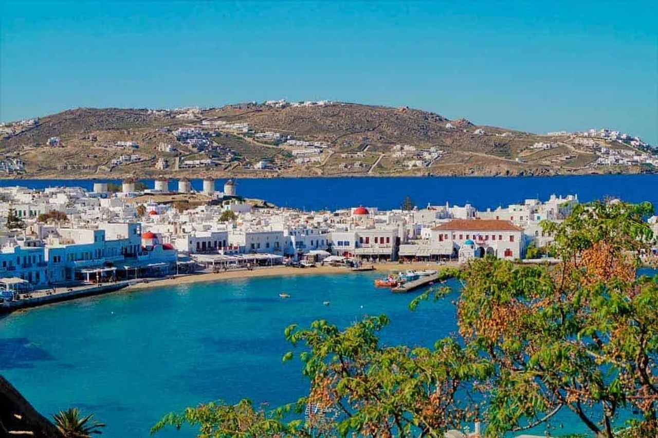 Vista da costa de Mykonos, com casas brancas e águas azuis.