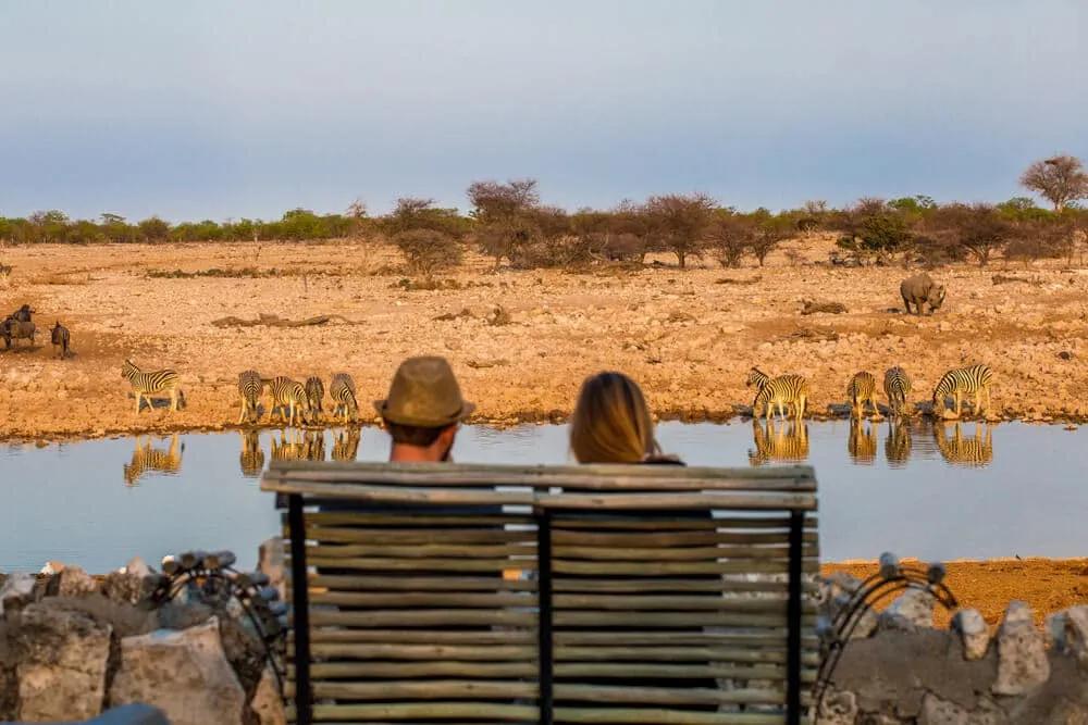 dois turistas a olhar para um lago na namibia