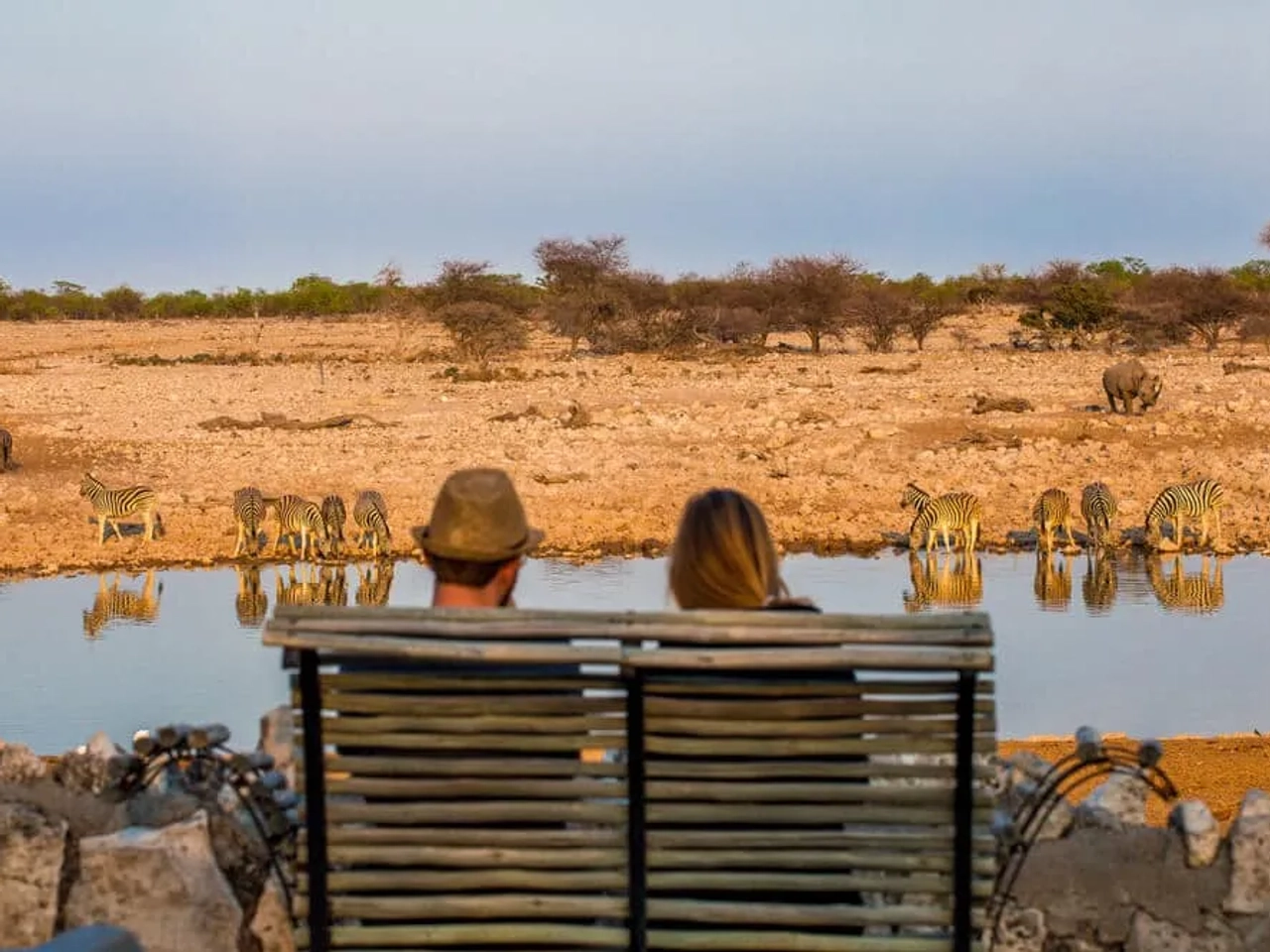 dois turistas a olhar para um lago na namibia