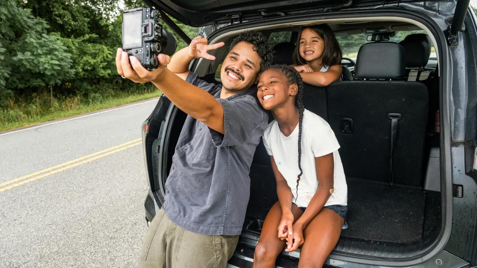Familia haciéndose una foto tras haber financiado un coche y protegido su inversión con un seguro de vida