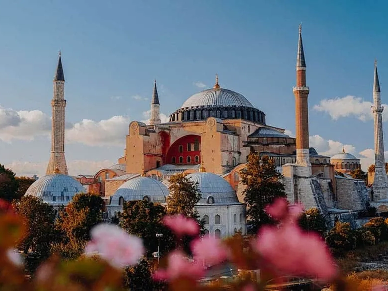 Mesquita Hagia Sophia em Istambul, com flores em primeiro plano e céu azul.