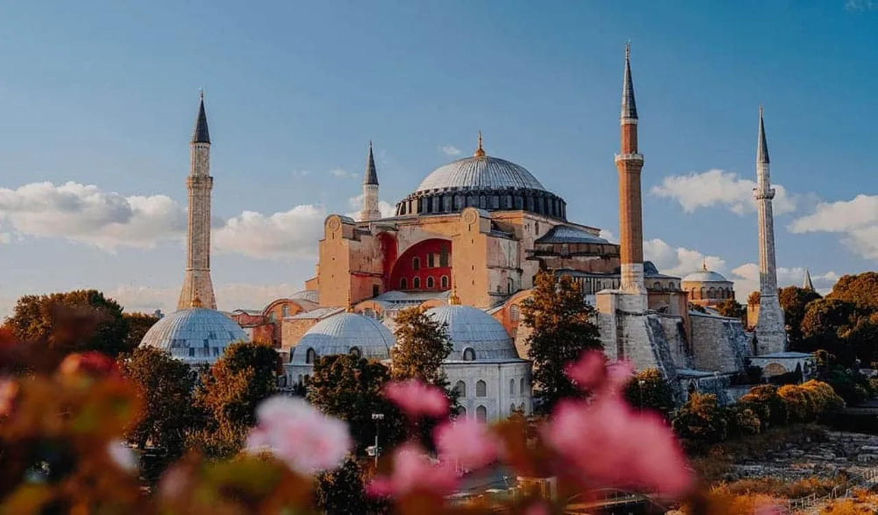 Mesquita Hagia Sophia em Istambul, com flores em primeiro plano e céu azul.