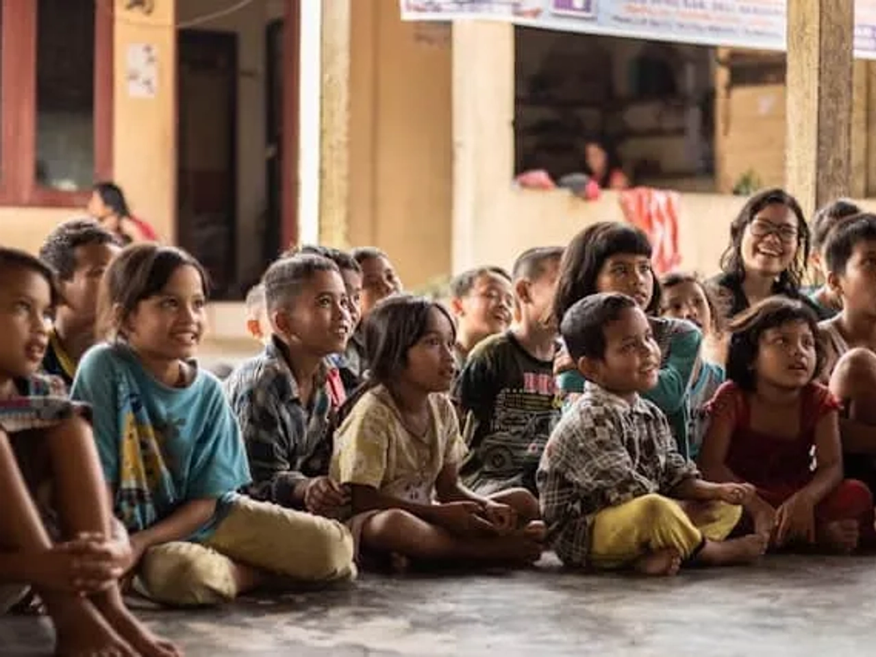 crianças felizes sentadas no chão de t shirt