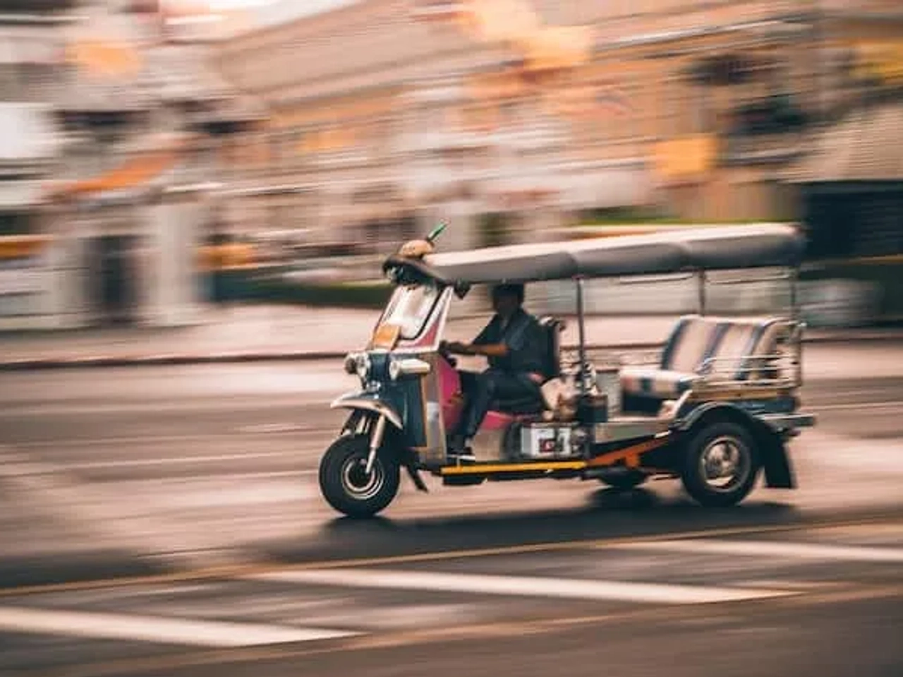 homem a conduzir um tuk tuk na tailândia