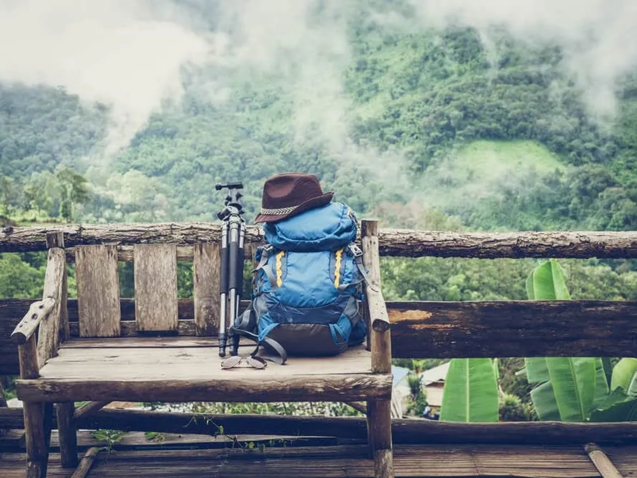 mochila e tripe pousados em cima de um banco