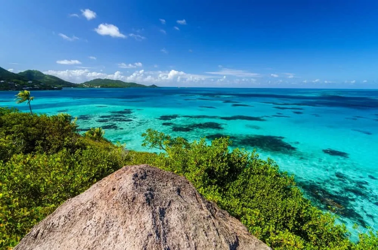 Praia de águas turquesa na Colômbia, com vegetação tropical junto à costa.