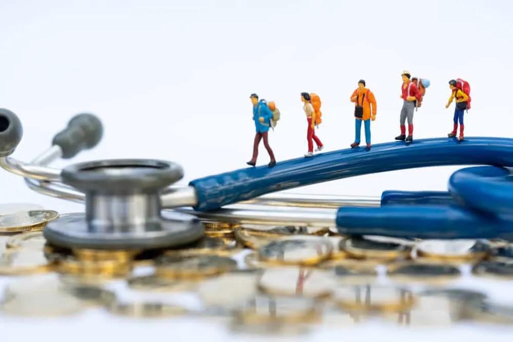 miniatura de viajantes em cima de um estetoscópio