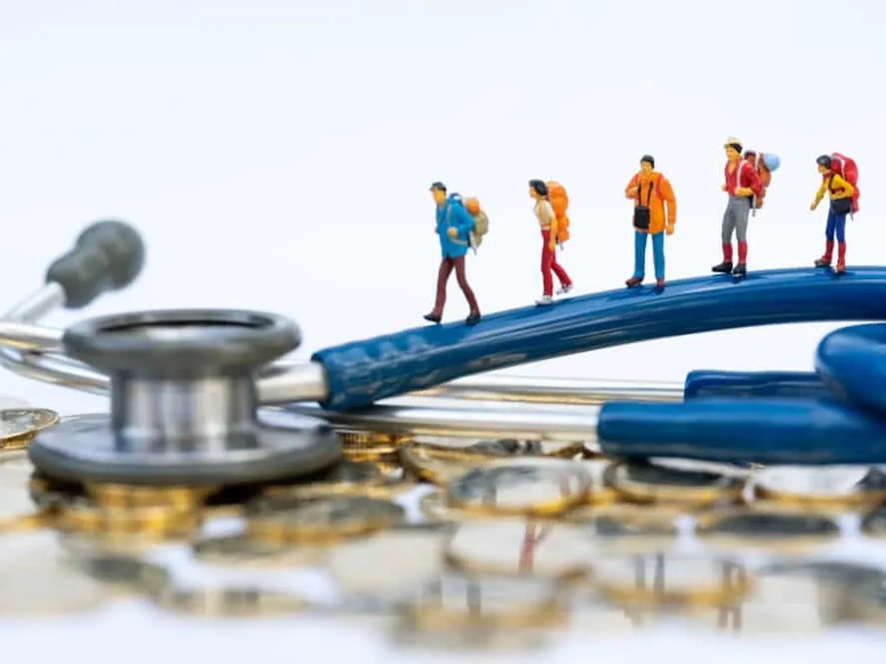 miniatura de viajantes em cima de um estetoscópio