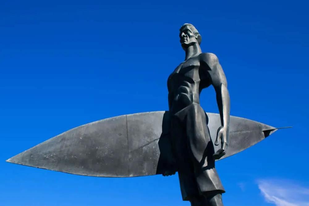 estatua dedicada ao surf em fundo de ceu azul