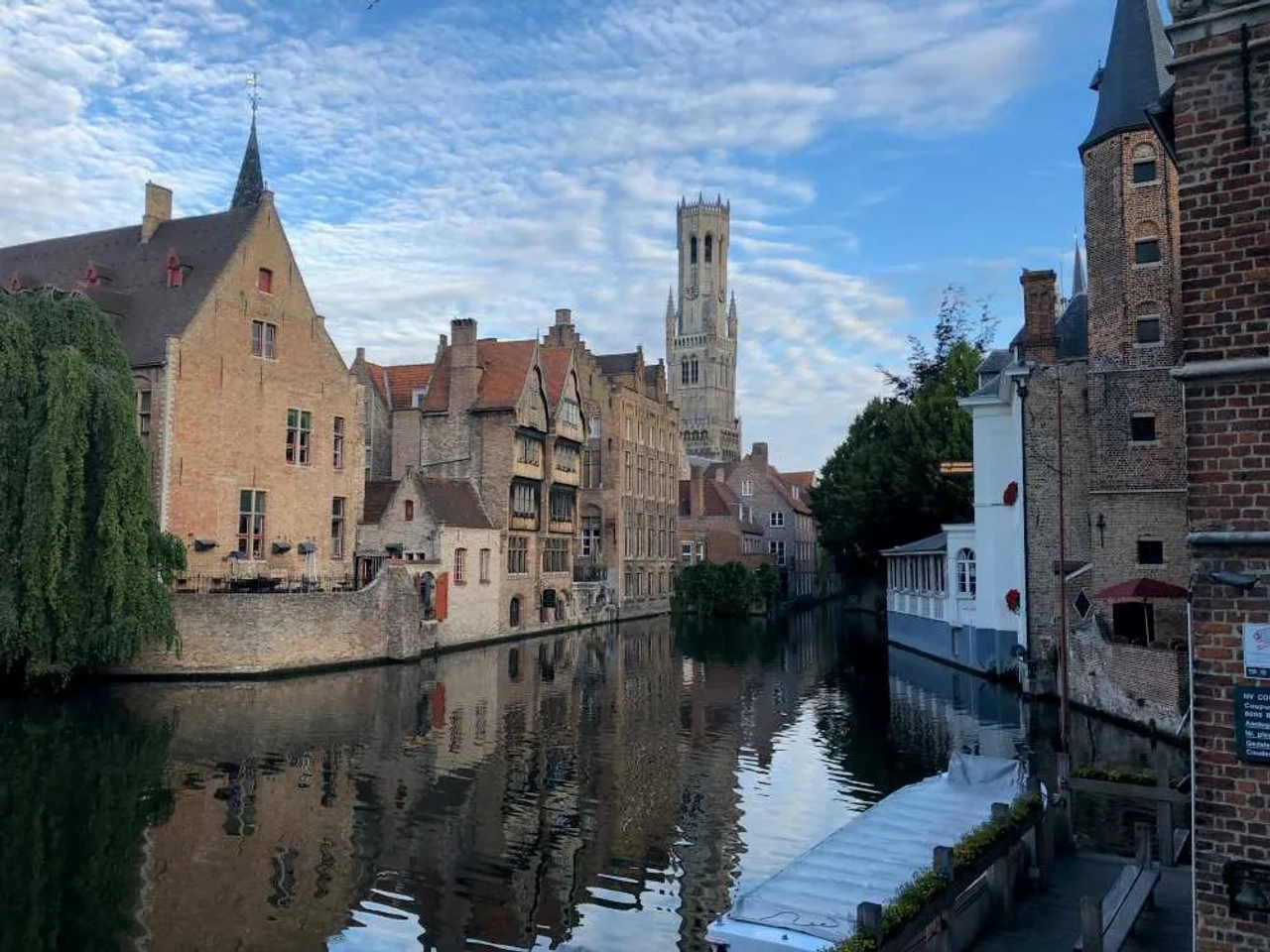 Canales y edificios históricos en Brujas, Bélgica, reflejados en el agua.
