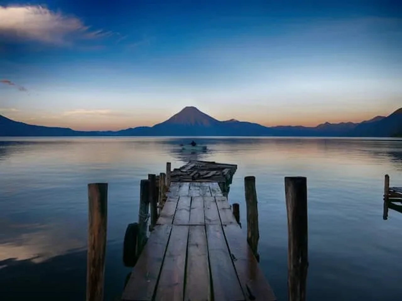 homem num caiaque ao por do sol em frente a uma montanha em Panajachel, Guatemala
