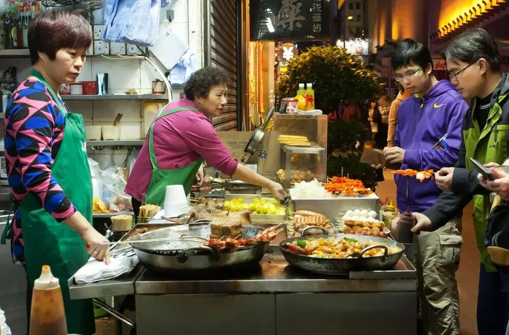 turistas vêm como se cozinham pratos típicos nas ruas de hong kong