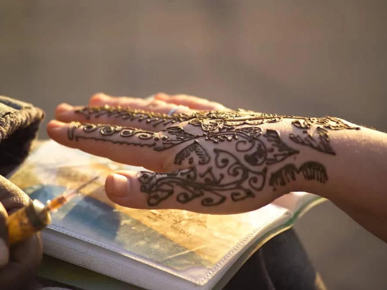 mao feminina com tatuagem de hena