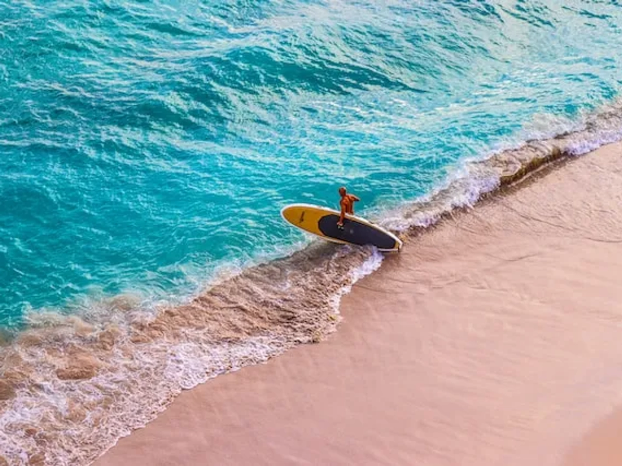 man with a surfboard in waikiki in hawaii