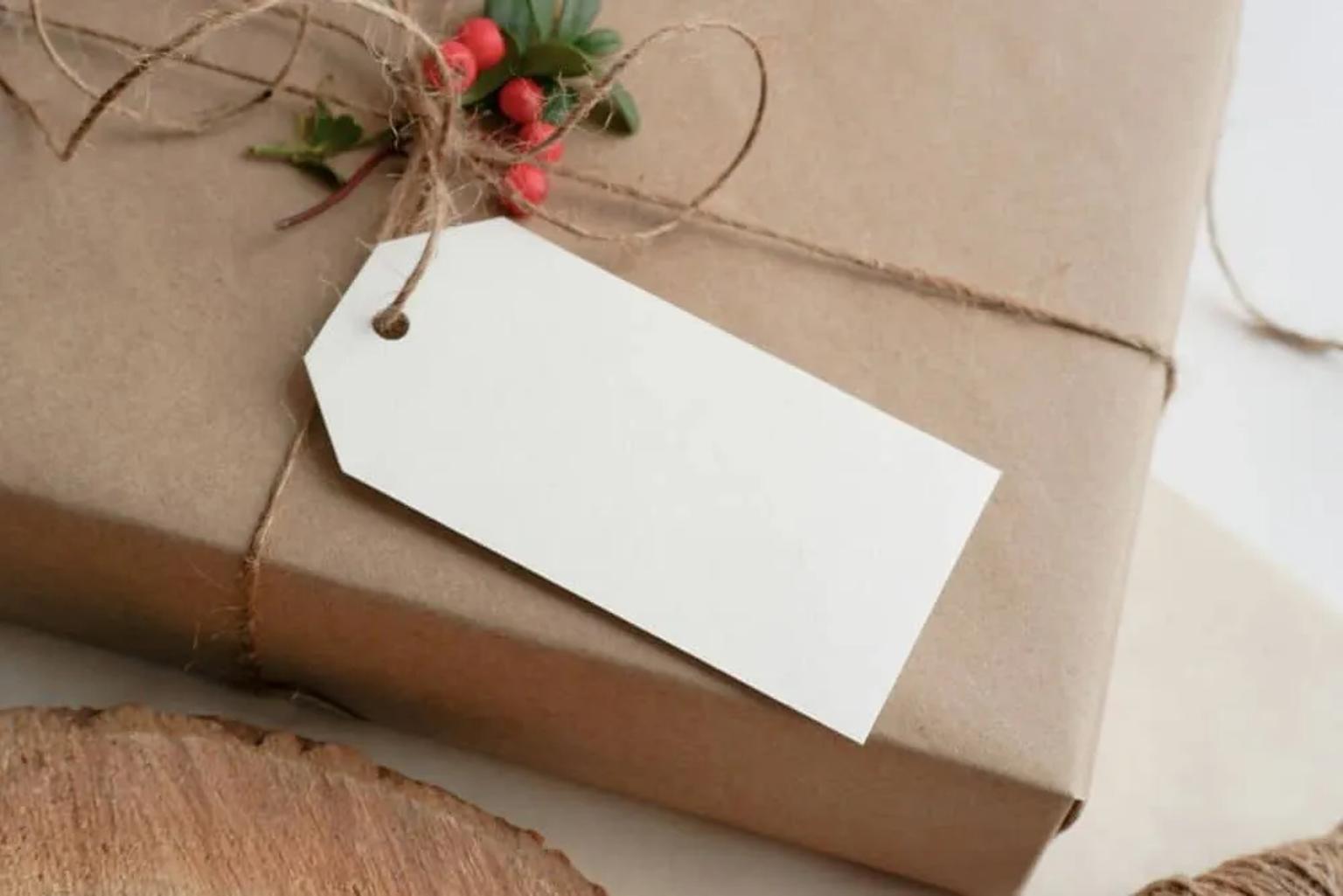 Regalo envuelto en papel kraft con etiqueta blanca y decoración natural.