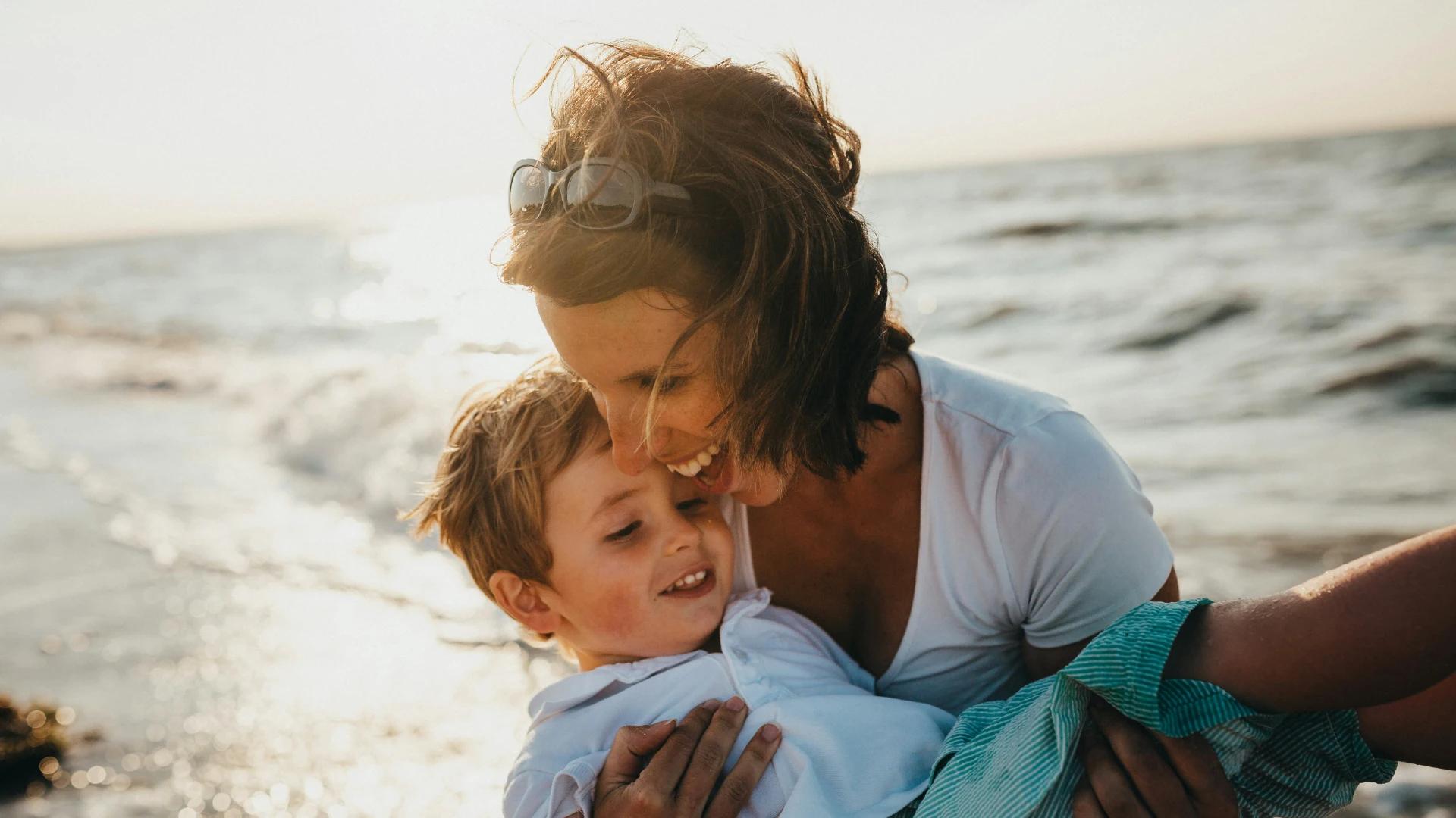 Madre juega con su hijo tras informarse adecuadamente sobre cuál es el mejor seguro de vida según su situación familiar.