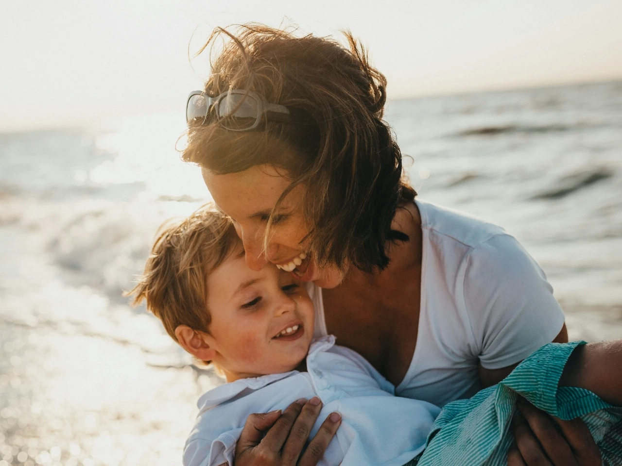 Madre juega con su hijo tras informarse adecuadamente sobre cuál es el mejor seguro de vida según su situación familiar.