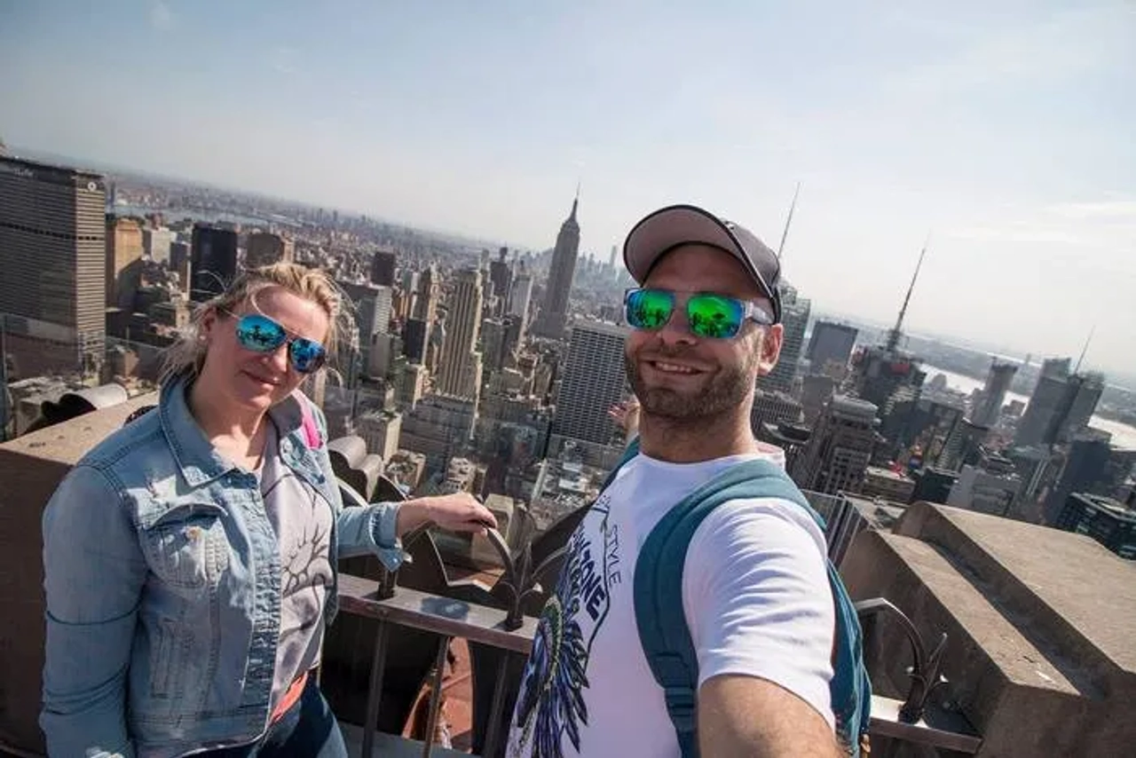 Pareja tomando un selfie en un mirador con vista a Nueva York.