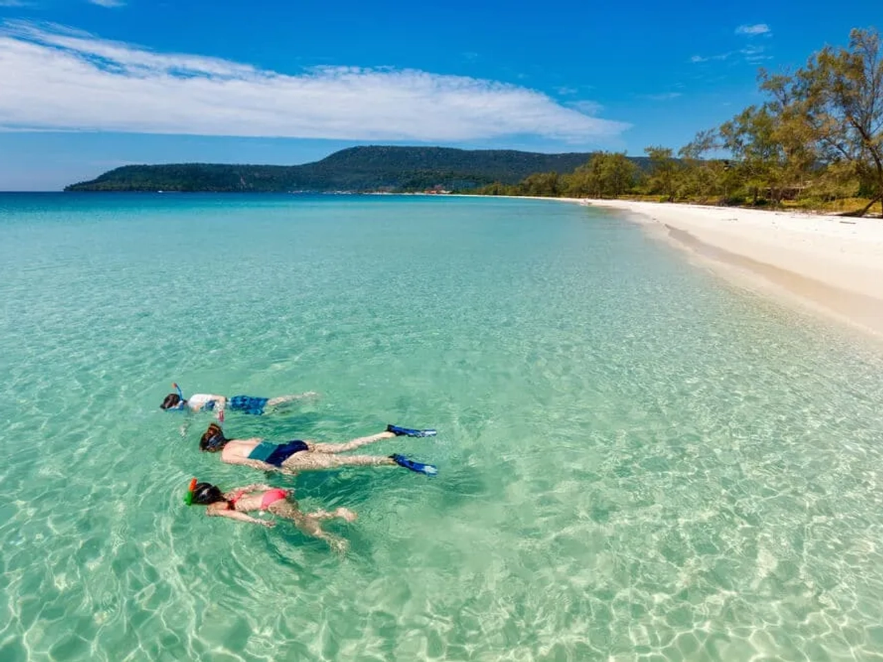 mães e dois filhos a fazer snorkeling em aguas cristalinas