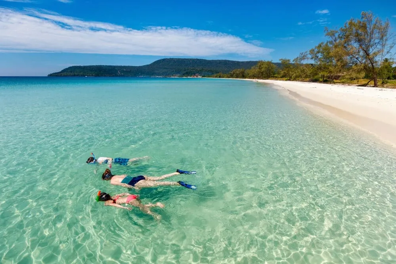 mães e dois filhos a fazer snorkeling em aguas cristalinas