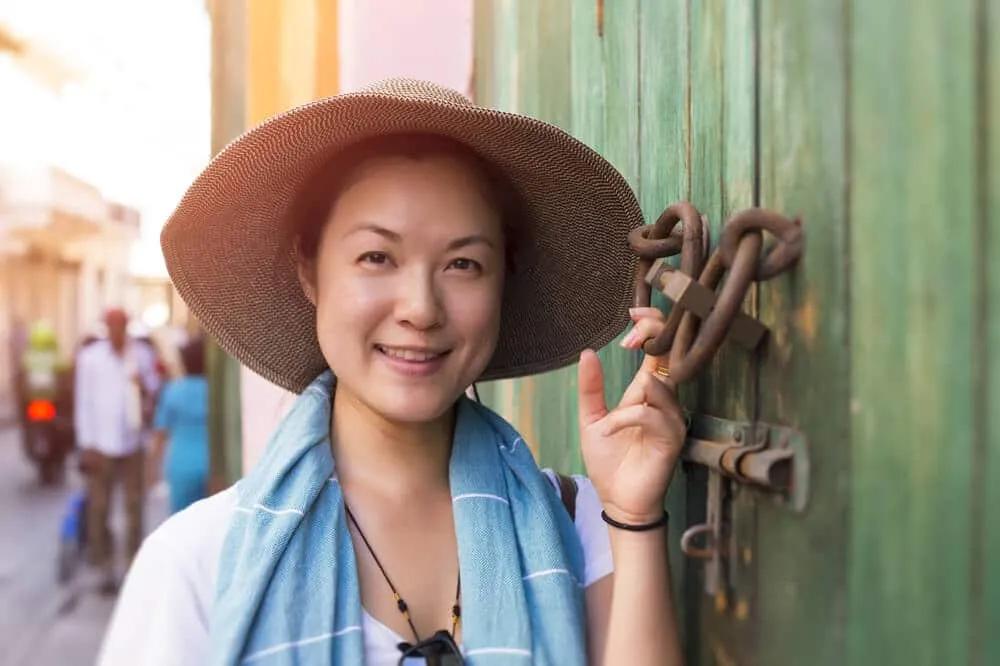 mulher asiatica a posar junto a porta verde