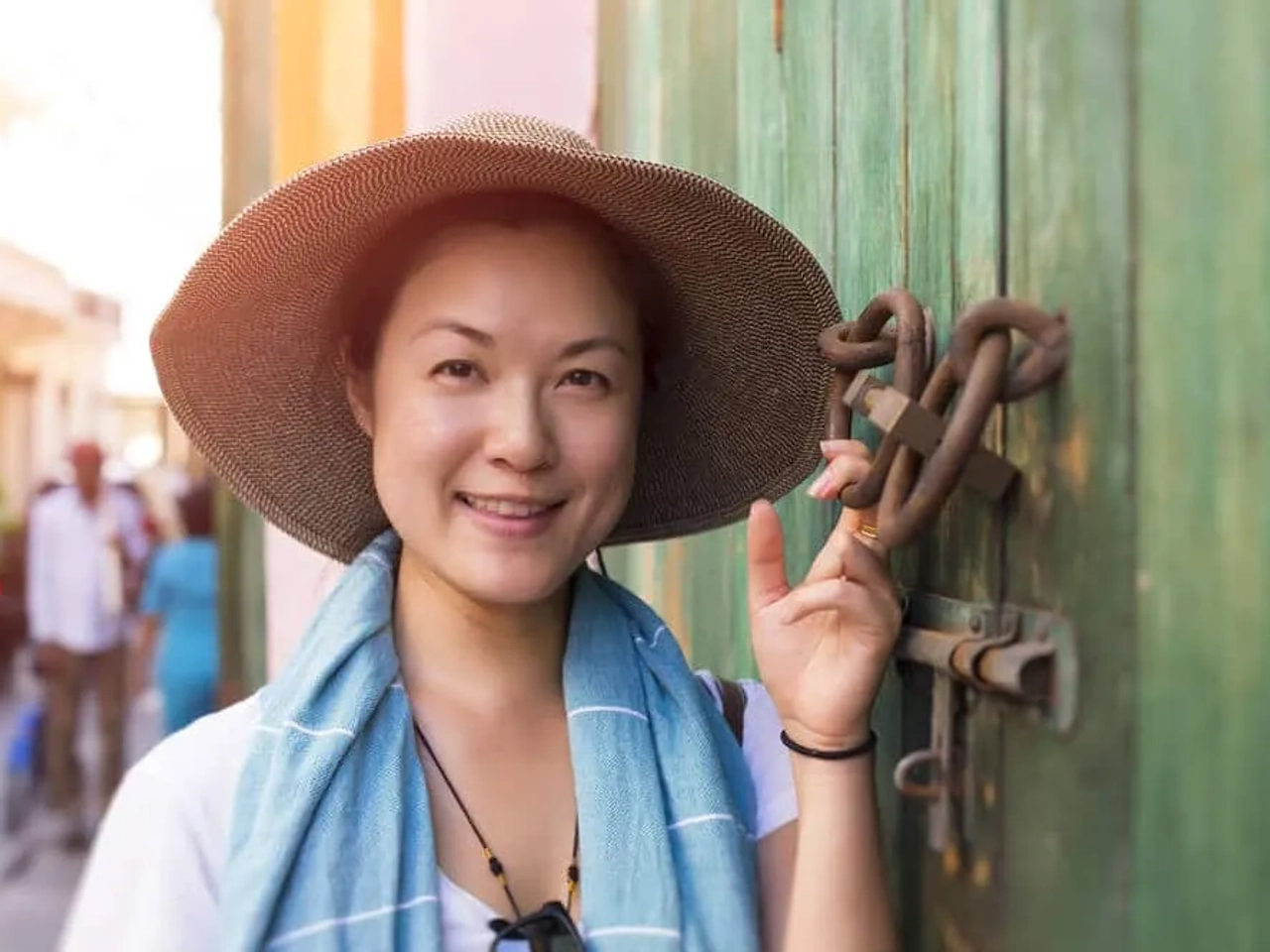 mulher asiatica a posar junto a porta verde