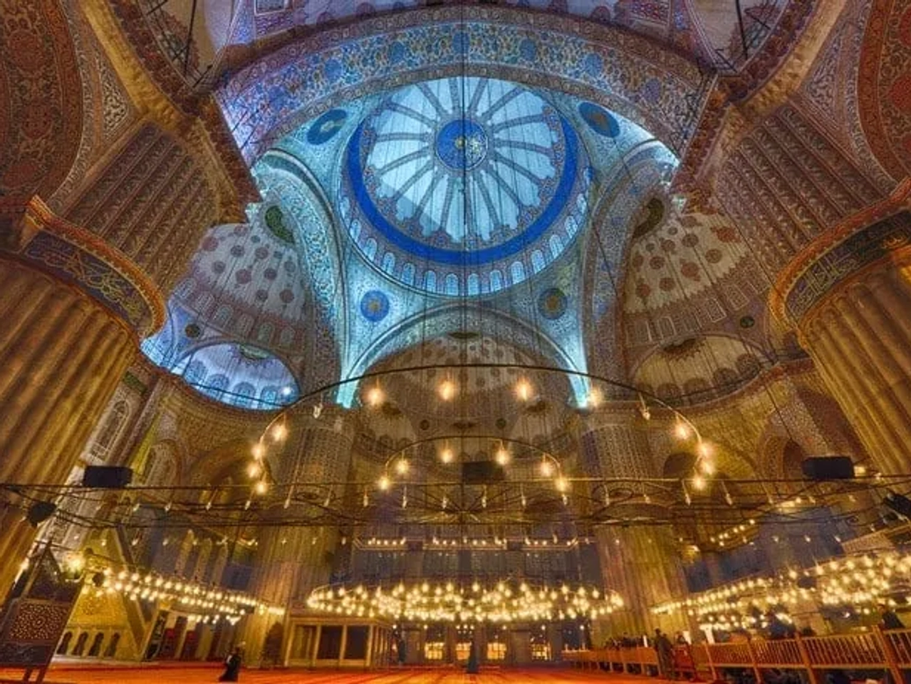 Interior da Mesquita Azul, destacando a cúpula e a iluminação decorativa.
