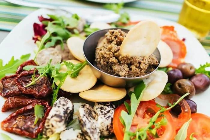 Prato variado com pastas, vegetais, azeitonas e ingredientes típicos de Malta.