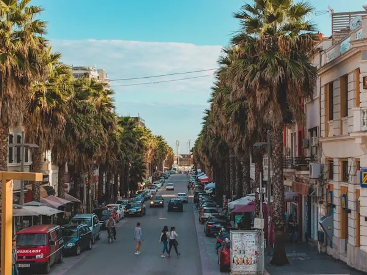 pessoas a caminhar numa avenida com carros em Durrës na Albania