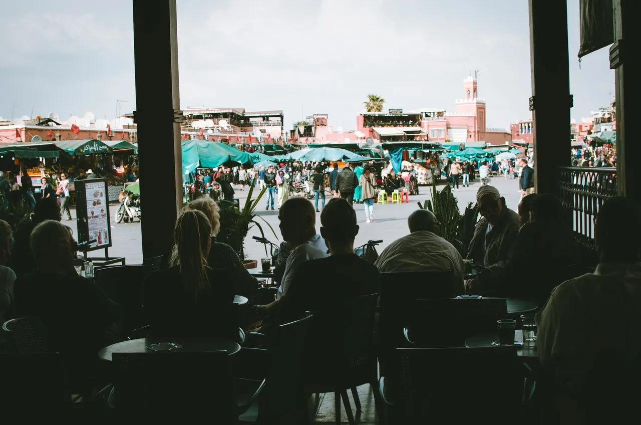 Mercato tradizionale di Marrakech con bancarelle e visitatori durante un viaggio in Marocco.