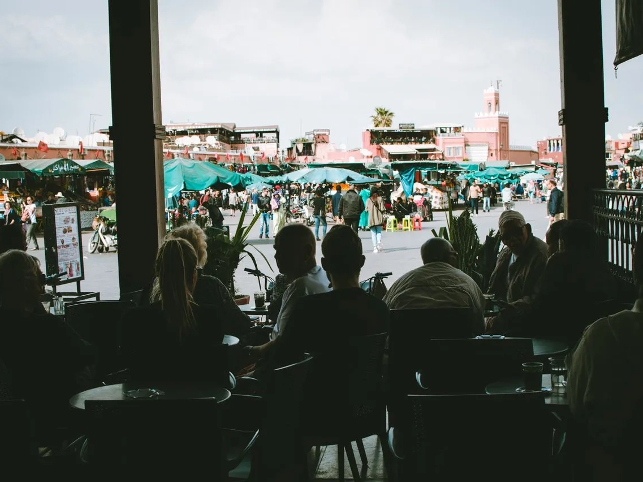 Mercato tradizionale di Marrakech con bancarelle e visitatori durante un viaggio in Marocco.