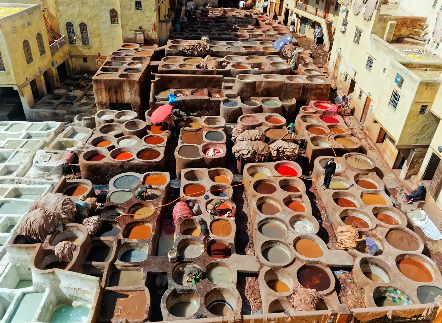 Concerie tradizionali di Fès viste dall’alto, con vasche colorate per la lavorazione delle pelli durante un itinerario di 7 giorni in Marocco.