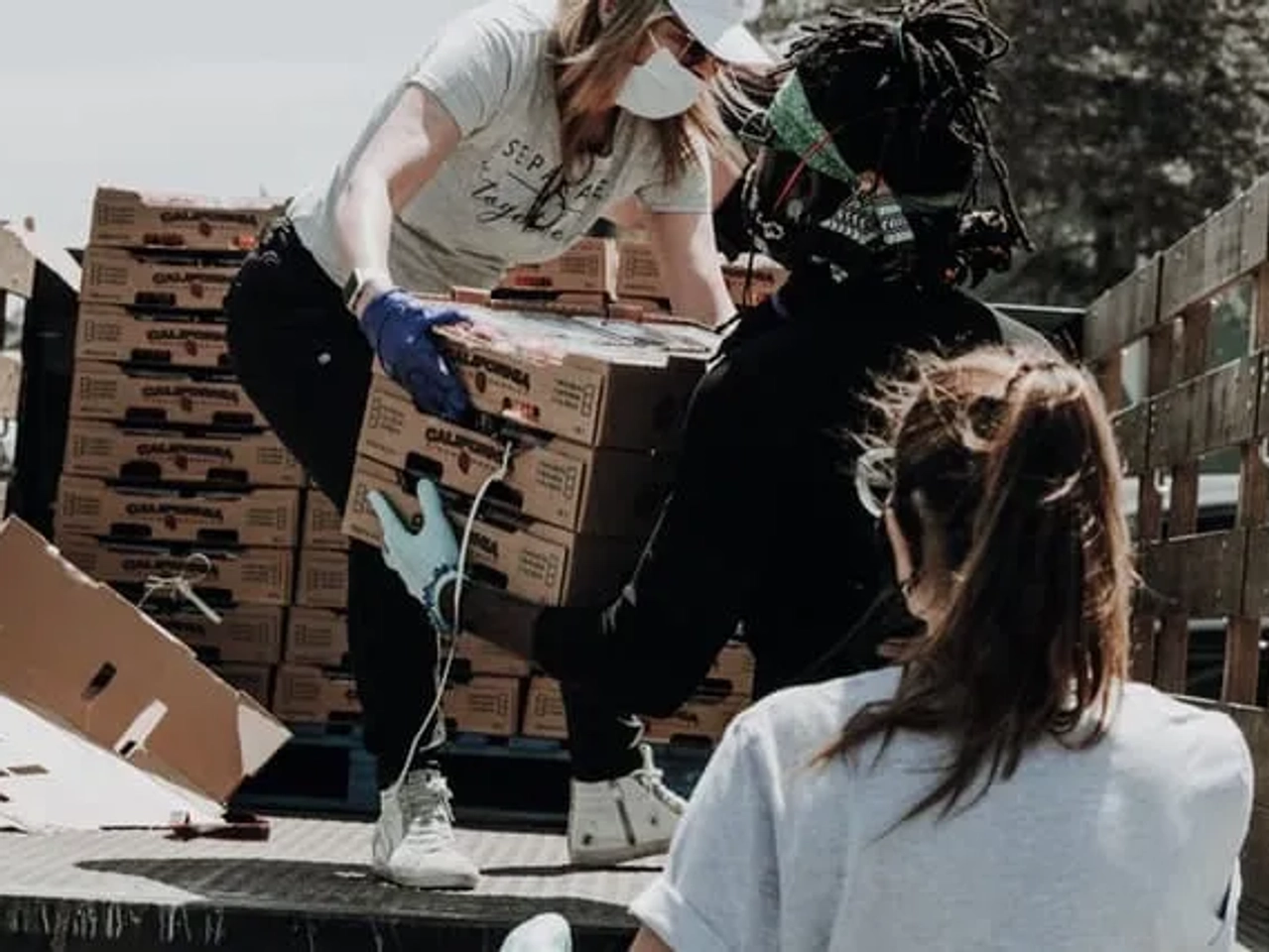 senhora a descarregar caixas e a dar a outra senhora