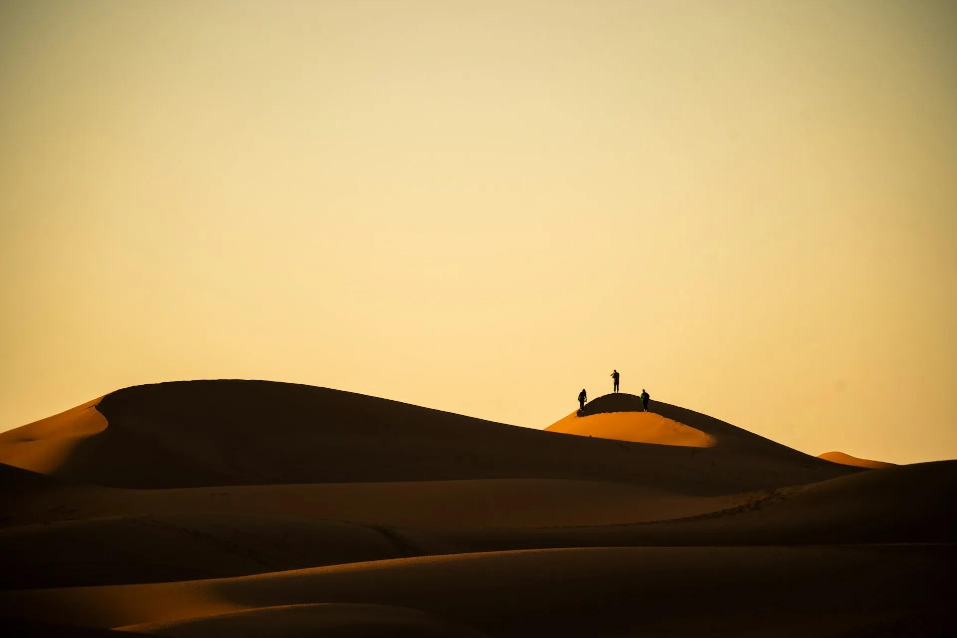 Viaggiatori sulle dune del deserto in Marocco, esperienza da organizzare con guide affidabili e operatori autorizzati.