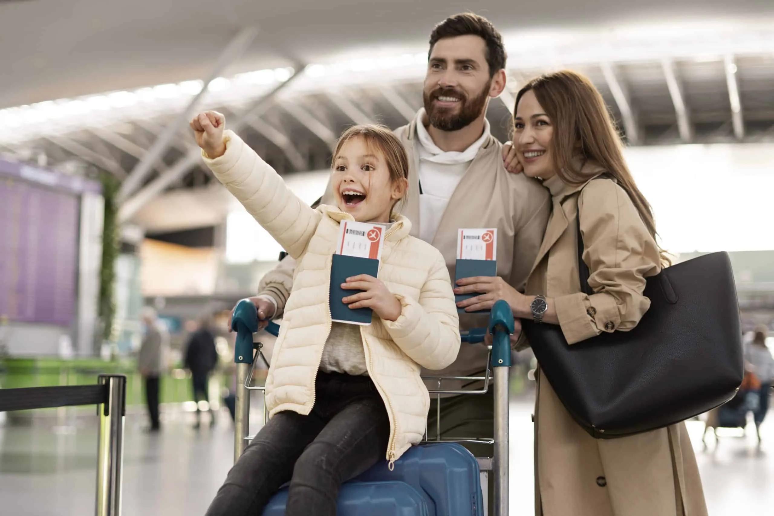 Família sorridente no aeroporto, segurando passagens e bagagem.