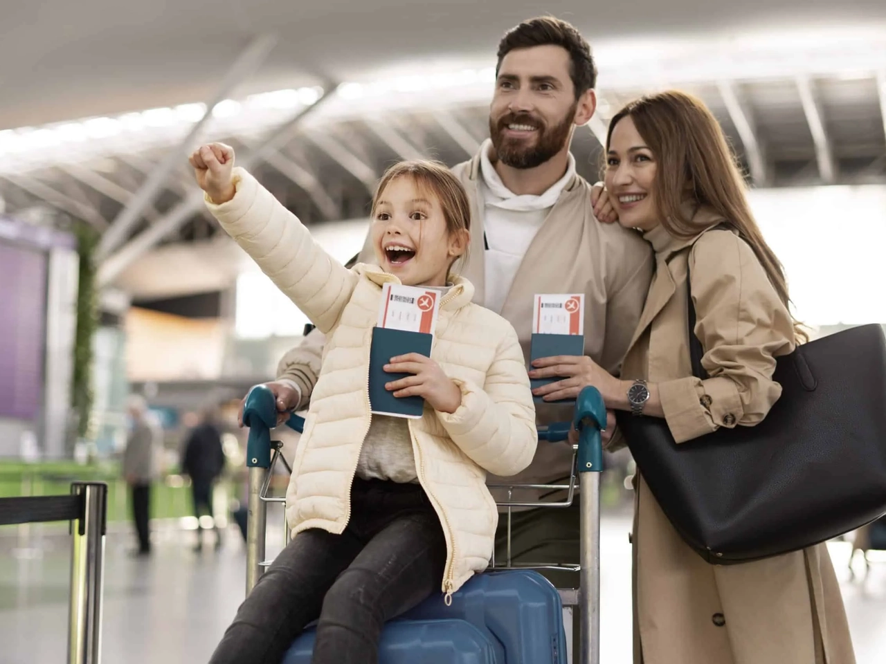 Família sorridente no aeroporto, segurando passagens e bagagem.