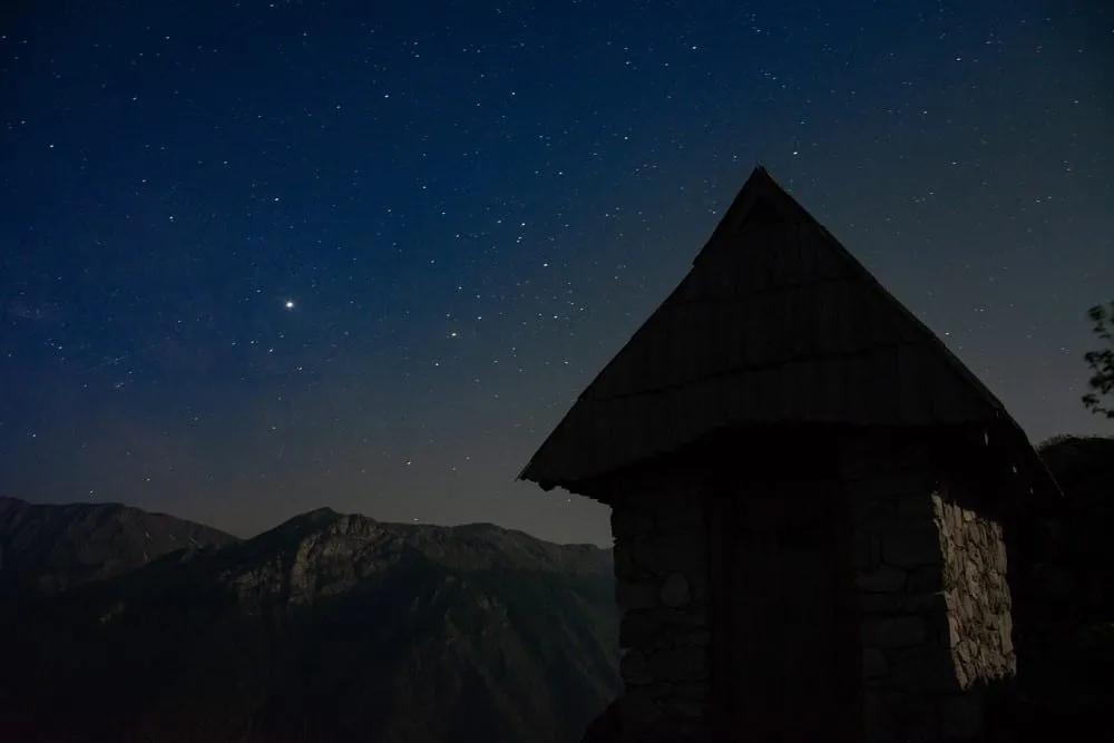 Casa de piedra bajo un cielo estrellado en las montañas de Bosnia.