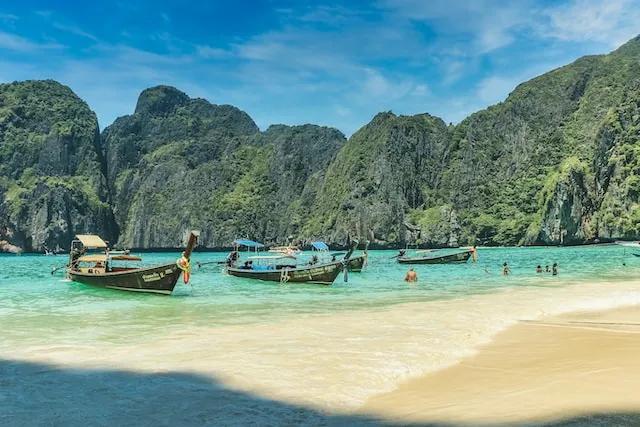 three boats on a beach in thailand