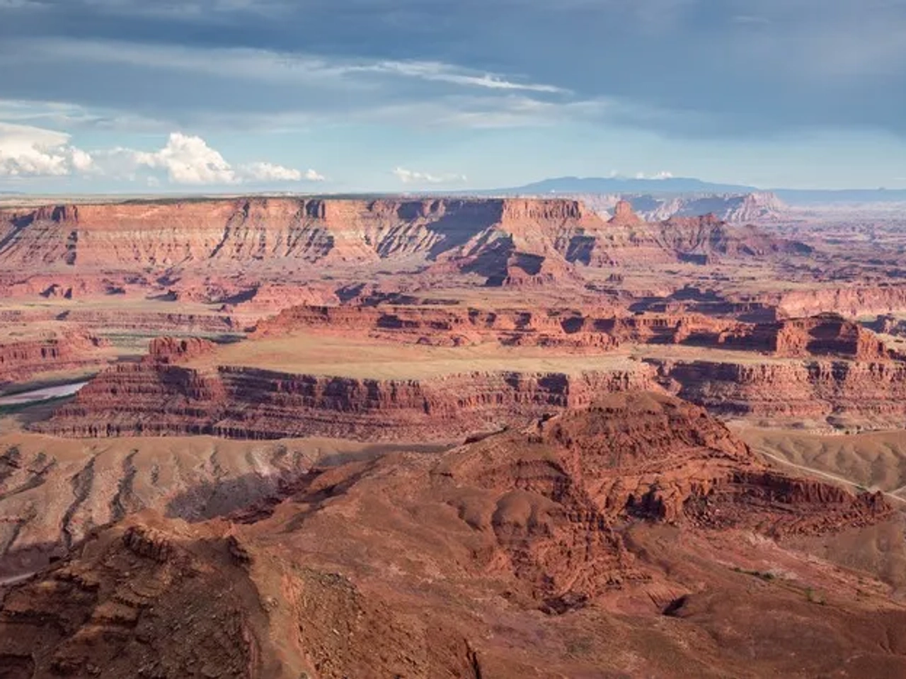 Vista panorámica del Gran Cañón con formaciones rocosas y cielo nublado.