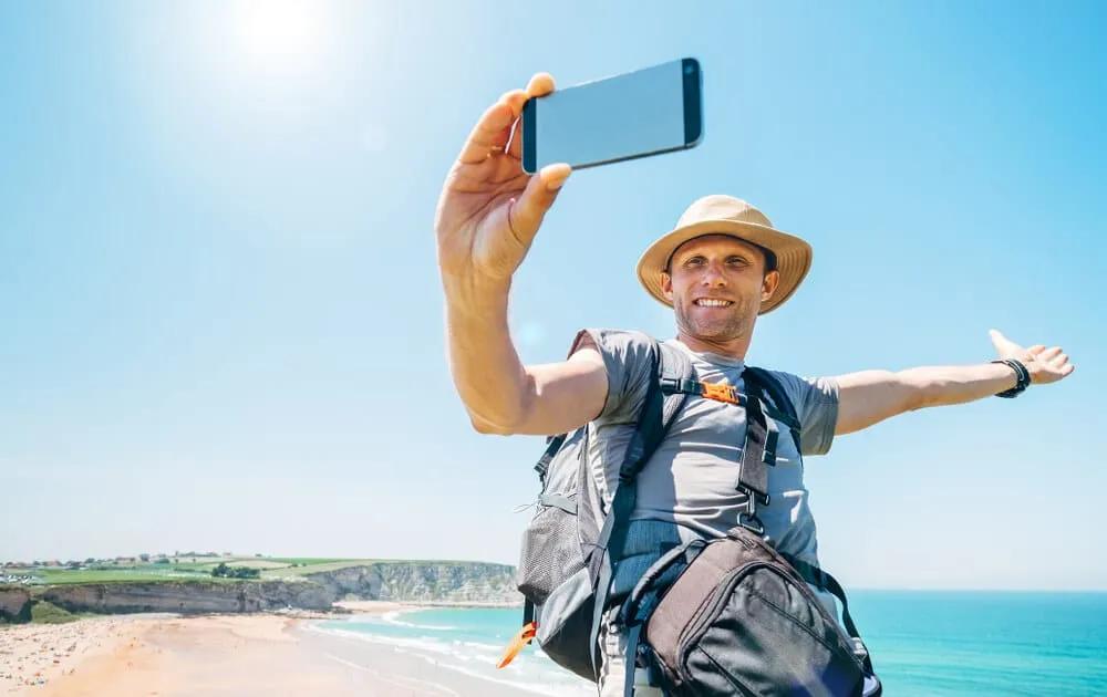 homem tira selfie sozinho numa praia